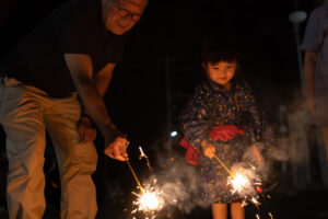 孫と花火をする祖父